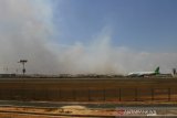 Pesawat Komersil mendarat di Bandara Syamsudin Noor dengan latar belakang kepulan asap membumbung tinggi dari kebarakan lahan gambut di Banjarbaru, Kalimantan Selatan, Rabu (11/9/2019).Berdasarkan data Badan Nasional Penanggulangan Bencana (BNPB) pada Rabu (11/9/2019) terdapat 5.062 titik panas yang terdeteksi dan jumlah lahan yang terbakar periode Agustus 2019 di seluruh provinsi yang terdampak mencapai 328.724 hektare.Foto Antaranews Kalsel/Bayu Pratama S.