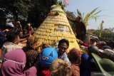 Pengunjung berebut gunungan berisi tahu takwa khas Kediri di Desa Toyoresmi, Kediri, Jawa Timur, Jumat (13/9/2019). Bersih desa pada bulan suro penanggalan Jawa tersebut sebagai perwujudan rasa syukur kepada Tuhan Yang Maha Esa sekaligus mempromosikan desa Toyoremi sebagai sentral perajin tahu takwa. Antara Jatim/Prasetia Fauzani/zk