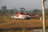 Prajurit TNI berjaga di dekat lokasi helikopter water bombing milik BNPB yang mendarat darurat di areal persawahan di kawasan Cempaka Banjarbaru, Kalimantan Selatan, Jumat (13/9/2019).Helikopter jenis Kamov Ka-32 milik BNPB yang digunakan untuk melakukan Water Bombing mendarat darurat saat mengambil air pada Kamis (12/9/2019) sore.ANTARA FOTO/Bayu Pratama S.