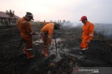 Kepala Dinas Kehutanan Hanif Faisol Nurofiq (kanan) bersama Satgas Kebakaran hutan dan Lahan (Karhutla) dari Dinas Kehutanan Kalsel menggunakan alat suntik gambut (Sunbut) saat berupaya memadamkan kebakaran lahan gambut di kawasan Syamsudin Noor, Banjarbaru, Kalimantan Selatan, Sabtu (14/9/2019). Berdasarkan pantauan satelit milik Lembaga Penerbangan dan Antariksa Nasional (LAPAN) Sabtu (14/9/2019) terdapat 2.720 hotspot di sejumlah wilayah yang ada di Indonesia. (Foto Antaranews Kalsel/Bayu Pratama S)