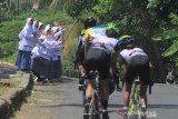 Sejumlah pelajar memberi semangat kepada pebalap saat mengikuti kategori Individual Time Trial pada International Tour de Linggarjati 2019 di Mandirancan, Kuningan, Jawa Barat, Jumat (13/9/2019). Ajang balap sepeda yang diikuti peserta dari berbagai negara tersebut mempertandingkan beberapa kategori diantaranya Individual Time Trial (ITT), Individual Road Race (IRR) dan Criterium. ANTARA JABAR/Dedhez Anggara/agr