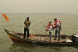 Seorang nelayan mendampingi wisatawan yang mencoba menjaring ikan saat mengikuti paket wisata budaya Pantai Timur Sumatera di Kampung Laut, Tanjungjabung Timur, Jambi, Minggu (8/9/2019). Dinas Pariwisata, Kebudayaan, Kepemudaan dan Olahraga Kabupaten Tanjungjabung Timur mengembangkan paket wisata melaut dengan melibatkan beberapa nelayan di Pantai Timur Sumatera daerah itu sebagai bagian dari upaya pengembangan destinasi wisata berbasis kearifan lokal. ANTARA FOTO/Wahdi Septiawan/wsj.