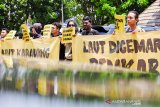 Seorang pengunjuk rasa yang tergabung dalam Koalisi Masyarakat Sipil Karawang membentangkan poster saat melakukan aksi solidaritas untuk pesisir Karawang di depan kantor DPRD, Karawang, Jawa Barat, Sabtu (14/9/2019). Aksi tersebut bertujuan untuk menuntut pemerintah Kabupaten Karawang melakukan pendampingan kepada masyarakat pesisir dan memulihan ekosistem laut, pantai dan mangrove serta melakukan audit terhadap seluruh pihak terkait terdampak tumpahan minyak di pesisir Karawang. ANTARA JABAR/M Ibnu Chazar/agr