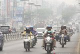 Pengendara kendaraan bermotor menggunakan masker pelindung pernapasan ketika melintas di Fly Over jalan Ahmad Yani yang terpapar kabut asap di Banjarmasin, Kalimantan Selatan, Minggu (15/9/2019).Kebakaran hutan dan lahan (Karhutla) di sejumlah wilayah Provinsi Kalsel mengakibatkan Kota Banjarmasin terpapar kabut asap dengan aroma yang menyengat dan bertambah pekat dalam beberapa hari terakhir.Foto Antaranews Kalsel/Bayu Pratama S.