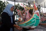 Pengunjung melihat miniatur kapal slerek yang dipamerkan di Tempat Pelelangan Ikan Muncar Banyuwangi, Jawa Timur, Minggu (15/9/2019). Produksi miniatur kapal  yang dijual sebagai oleh-oleh khas nelayan Muncar tersebut,  dipasarkan berkisar Rp700 ribu hingga Rp3 juta. Antara Jatim/Budi Candra Setya/zk.
