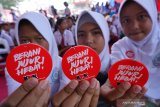 Sejumlah siswa menunjukkan pin berwarna dasar merah-putih dengan tulisan 