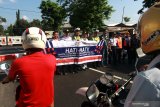 Sejumlah petugas jaga lintasan bersama Kepolisian dan Dishub membentangkan spanduk peringatan berhati-hati di palang pintu kereta api di Argopuro, Banyuwangi, Jawa Timur, Rabu (18/9/2019). Sosialisasi  tersebut, sebagai himbauan kepada masyarakat untuk mematuhi peraturan di perlintasan sebidang guna mengurangi angka kecelakaan. Antara Jatim/Budi Candra Setya/zk.