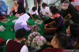 Sejumlah peserta mengikuti pelatihan pembuatan hantaran pernikahan dengan bahan baku uang kertas palsu di Kota Kediri, Jawa Timur, Kamis (19/9/2019). Kegiatan yang diselenggarakan pemerintah daerah setempat dan didukung Bank Indonesia tersebut bertujuan mendorong masyarakat berwirausaha sekaligus sosialisasi larangan merusak uang kertas sebagai bahan baku pembuatan hantaran pernikahan. Antara Jatim/Prasetia Fauzani/zk.