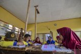 Siswa mengikuti kegiatan belajar mengajar didalam kelas yang rusak di SDN Pasirhuni 2, Kampung Cipaheuteun, Kabupaten Tasikmalaya, Jawa Barat, Kamis (19/9/2019). Bangunan ruang kelas empat tersebut rusak sejak dua tahun lalu akibat dimakan usai, sehingga pihak sekolah menopang atap flafonnya menggunakan bambu dan hingga kini belum mendapat perhatian dari pemerintah setempat. ANTARA FOTO/Adeng Bustomi/agr