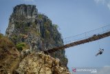 Seorang wisatawan menuruni jembatan di karst Citatah, Kabupaten Bandung Barat, Jawa Barat, Kamis (19/9/2019). Pemerintah Provinsi Jawa Barat menargetkan kawasan karst Citatah akan berstatus Geopark Nasional pada 2020 dan menjadi salah satu kawasan wisata unggulan di Jawa Barat. ANTARA FOTO/Raisan Al Farisi/agr