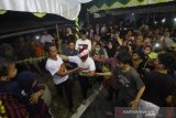 Warga menenangkan penari yang kesurupan saat menampilkan tari manopeng pada Pagelaran Tradisi Manopeng di Desa Banyiur Luar, Banjarmasin, Kalimantan Selatan, Minggu (22/9/2019).Pagelaran Tradisi Manopeng tersebut selain melestarikan tradisi keluarga sekaligus ajang promosi pariwisata daerah.Foto Antaranews Kalsel/Bayu Pratama S.