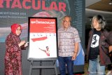 Wali Kota Surabaya Tri Rismaharini (kiri) bersama Dirpem LKBN Antara Akhmad Munir (tengah) dan Kepala Divisi Galeri Foto Jurnalistik Antara (GFJA) Oscar Motuloh (kanan) menandatangani foto  saat pembukaan pameran foto Sportacular di Gedung Siola (Surabaya Museum), Surabaya, Jawa Timur, Sabtu (21/9/2019). Pameran yang memajang 68 foto karya 37 pewarta tersebut menampilkan foto-foto Asian Games dan Asian Para Games 2018 serta beberapa olahraga tradisonal Nusantara. Antara Jatim/Saiful Bahri/zk.