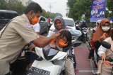 Petugas BPBA membantu memakaikan masker pada pengemudi sepeda motor mengenakan masker seusai dibagikan oleh petugas Badan Penanggulangan Bencana Aceh (BPBA) di Bundaran Simpang Lima, Banda Aceh, Aceh, Senin (23/9/2019). Pemerintah Aceh melalui BPBA membagikan sekitar 90.000 masker kepada masyarakat di sembilan kabupaten/kota di provinsi Aceh yang terdampak kabut asap kiriman akibat kebakaran hutan dan lahan (karhutla) dari sejumlah daerah di Sumatera. Antara Aceh/Ampelsa.