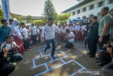 Gubernur Jawa Barat Ridwan Kamil bermain permainan tradisional engkle bersama siswa saat gerakan asik tanpa gawai di Gedung Sate Bandung, Jawa Barat, Selasa (24/9/2019). Acara yang diikuti 700 anak dari SD hingga SMA di Kota Bandung tersebut dilakukan guna mendorong anak-anak agar aktif bermain di luar rumah tanpa menggunakan gawai. ANTARA JABAR/Raisan Al Farisi/agr