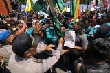 Massa mahasiswa terlibat aksi dorong dengan polisi saat berunjuk rasa di depan gedung DPRD Kabupaten Kediri, Jawa Timur, Rabu (25/9/2019). Ratusan mahasiswa dari sejumlah perguruan tinggi yang tergabung dalam Aliansi Mahasiswa Kediri turun ke jalan guna menyerukan penolakan terhadap Rancangan Undang-Undang Pertanahan yang dinilai menciderai amanat reformasi. Antara Jatim/Prasetia Fauzani/zk.