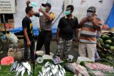 Personil Polsek Kuta Alam, Polresta Banda Aceh membagikan dan mensosialisasikan cara penggunaan masker kepada pedagang kaki lima (PKL) serta pengunjung pasar tradisional di Peunayong, Banda Aceh, Aceh, Rabu (25/9/2019). Sosialiasasi cara penggunaan masker dengan benar diharapkan dapat mencegah gangguan pernapasan karena kabut asap yang terjadi akibat kebakaran hutan dan lahan yang telah berdampak terhadap memburuknya kualitas udara. Antara Aceh/Irwansyah Putra.