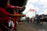 Pelajar menyemangati Pebalap sepeda pada Kejuaraan Internasional Tour de Banyuwangi Ijen (ITdBI) 2019 etape kedua di Banyuwangi, Jawa Timur, Kamis (26/9/2019).  Pada etape kedua ITdBI 2019 dimulai dari Taman Nasional Alas Purwo dan finis di halaman Pemkab Banyuwangi dengan menempuh jarak 148,2 kilometer. Antara Jatim/Budi Candra Setya/zk.