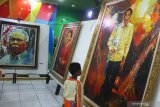 Seorang anak melihat lukisan karya Jupri Abdullah dalam  Pameran Lukisan Toko0h Bangsa di Perpustakan Pusat Malang, Jawa Timur, Kamis (26/9/2019). Pameran yang berlangsung selama sepuluh hari tersebut menampilkan puluhan lukisan portrait tokoh bangsa mulai dari Presiden Joko Widodo hingga Ketua DPR Bambang Soesatyo. Antara Jatim/Ari Bowo Sucipto/zk