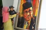 Pengunjung melihat lukisan mantan Presiden RI, BJ Habibie karya Jupri Abdullah dalam  Pameran Lukisan Toko0h Bangsa di Perpustakan Pusat Malang, Jawa Timur, Kamis (26/9/2019). Pameran yang berlangsung selama sepuluh hari tersebut menampilkan puluhan lukisan portrait tokoh bangsa mulai dari Presiden Joko Widodo hingga Ketua DPR Bambang Soesatyo. Antara Jatim/Ari Bowo Sucipto/zk