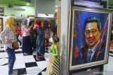 Pengunjung melihat lukisan mantan Presiden RI, Susilo Bambang Yudhoyono karya Jupri Abdullah dalam  Pameran Lukisan Toko0h Bangsa di Perpustakan Pusat Malang, Jawa Timur, Kamis (26/9/2019). Pameran yang berlangsung selama sepuluh hari tersebut menampilkan puluhan lukisan portrait tokoh bangsa mulai dari Presiden Joko Widodo hingga Ketua DPR Bambang Soesatyo. Antara Jatim/Ari Bowo Sucipto/zk