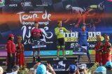 Pebalap sepeda Team UKYO Robbie Hucker (tengah) menaiki podium setelah menjadi yang terbaik pada gelaran Internasional Tour de Banyuwangi Ijen (ITdBI) 2019 di Banyuwangi, Jawa Timur, Sabtu (28/9/2019). Antara Jatim/Budi Candra Setya/zk