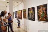 Pengunjung mengamati lukisan yang dipamerkan di ruang pameran Indigo Art Space di Kota Madiun, Jawa Timur, Sabtu (28/9/2019) malam. Pameran lukis bertajuk Kunci Emas yang menampilkan sekitar 50 lukisan karya sembilan pelukis dari Yogyakarta, Gianyar (Bali), Solo (Jawa Tengah) dan Madiun (Jawa Timur) yang tergabung dalam Kelompok Lintas Kota tersebut rencananya berlangsung hingga 20 Oktober mendatang. Antara Jatim/Siswowidodo/zk