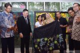 Salah seorang pelukis batik Erida Irawati (ketiga kiri) memberikan cendera mata kepada Wakil Walikota Madiun Inda Raya (keempat kiri) saat pembukaan Pameran Batik Lukis di Hotel Aston, Kota Madiun, Jawa Timur, Senin (30/9/2019). Pameran Batik Lukis bertajuk Tetes, Titis, Tatas diikuti 11 pelukis batik dari Madiun dan Ponorogo, Jawa Timur memajang sekitar 30 karya lukisan batik tersebut berlangsung hingga 14 Oktober mendatang. Antara Jatim/Siswowidodo/zk.