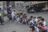Sejumlah pelajar yang diamankan turun dari truk di halaman Polres Metropolitan Bekasi, Jawa Barat, Senin (30/9/2019). Polres Bekasi menghalau dan mengamankan 150 pelajar yang akan mengikuti aksi demonstrasi ke DPR/MPR Senayan, Jakarta. ANTARA FOTO/Fakhri Hermansyah/nym.
