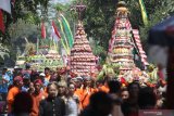 Warga mengarak sejumlah gunungan berisi hasil bumi dan jajanan pasar saat tradisi Kebur Banyu Ubalan di kawasan wisata sumber air Ubalan, Desa Jarak, Kediri, Jawa Timur, Minggu (29/9/2019). Tradisi berebut gunungan dan saling siram air pada bulan Suro penanggalan Jawa tersebut sebagai upaya warga sekitar menjaga kelestarian mata air sekaligus sarana promosi wisata. Antara Jatim/Prasetia Fauzani/zk