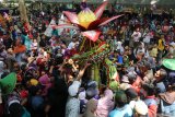 Pengunjung berebut gunungan berisi hasil bumi dan jajanan pasar saat tradisi Kebur Banyu Ubalan di kawasan wisata sumber air Ubalan, Desa Jarak, Kediri, Jawa Timur, Minggu (29/9/2019). Tradisi berebut gunungan dan saling siram air pada bulan Suro penanggalan Jawa tersebut sebagai upaya warga sekitar menjaga kelestarian mata air sekaligus sarana promosi wisata. Antara Jatim/Prasetia Fauzani/zk