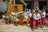 Sejumlah murid bersama gurunya membawa meja dari salah satu ruang kelas yang ambruk di SDN Kalangsurya III, Rengasdengklok, Karawang, Jawa Barat, Senin (30/9/2019).  Ambruknya atap bangunan sekolah yang terdiri dari dua ruang kelas dan satu ruang guru itu terjadi pada Minggu (29/9/2019) diakibatkan karena kondisi bangunan yang sudah lapuk dan tidak terawat, sementara siswa dipindahkan ke ruang kelas lainnya. ANTARA FOTO/M Ibnu Chazar/agr