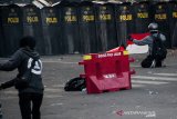 Massa yang tergabung dari Mahasiswa dan pelajar membentangkan bendera merah putih ke arah petugas kepolisian saat bentrok unjuk rasa di depan Gedung DPRD Jawa Barat, Bandung, Jawa Barat, Senin (30/9/2019).Aksi yang menuntut DPR segera mencabut seluruh Rancangan Undang Undang yang dianggap bermasalah serta menuntut Pemerintah Indonesia Khususnya Presiden untuk segera menerbitkan Perppu UU KPK berakhir ricuh. ANTARA FOTO/Novrian Arbi/agr