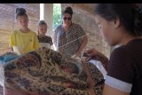 Wisatawan menyaksikan proses pembuatan batik khas Bali pada Hari Batik Nasional di Sentra Kerajinan Batik Tohpati, Denpasar, Bali, Rabu (2/10/2019). Kegiatan tersebut untuk mempromosikan dan memperkenalkan batik beragam motif yang berasal dari berbagai daerah di Indonesia yang sebagian besar diminati wisatawan mancanegara asal Eropa, Amerika dan Jepang. ANTARA FOTO/Nyoman Hendra Wibowo/nym.