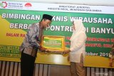 Dirjen Industri Kecil Menengah dan Aneka (IKMA) Kementerian Perindustrian (Kemenperin) Gati Wibawaningsih (kanan) memberikan bantuan mesin pembuat roti pada pengasuh pondok pesantren saat pelatihan Bimbingan Teknis Wirausaha baru berbasis Pondok Pesantren di Banyuwangi, Jawa Timur, Jumat (4/10/2019). Pelaksanaan program Santripreneur yang diinisiasi oleh Kemenperin itu, diharapkan dapat menambah kegiatan positif bagi para santri di lingkungan pondok sehingga dapat berguna bagi masyarakat dalam menumbuhkan perekonomian daerah setempat seperti penyerapan tenaga kerja. Antara Jatim/Budi Candra /zk