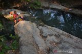 Warga melakukan aktifitas mencuci di sungai telimo yang kondisinya kotor di Desa Marmoyo, Kecamatan Kabuh, Kabupaten Jombang, Jawa Timur, Jumat (4/10/2019). Musim kemarau berkepanjangan sejak beberapa bulan terakhir membuat warga Desa setempat mengalami krisis air bersih, masyarakat terpaksa mandi dan mencuci di sungai yang kotor dan berlumut karena tidak ada sumber air lainnya. Sedangkan untuk minum, warga mengandalkan kiriman air bersih dari instansi terkait. Antara Jatim/Syaiful Arif/zk.