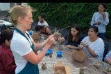 Seniman asal Amerika Serikat Courtney Mattison (kiri) menunjukkan cara membuat terumbu karang dari tanah liat dalam lokakarya pembuatan karang keramik di Kantor Coral Triangle Center (CTC), Denpasar, Bali, Senin (7/10/2019). Kegiatan yang diikuti sejumlah warga Bali dan wisatawan tersebut untuk menumbuhkan kesadaran masyarakat dalam konservasi terumbu karang melalui seni keterampilan pembuatan karang keramik. ANTARA FOTO/Nyoman Hendra Wibowo/nym.