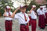 Sejumlah anak pencari suaka yang kini duduk di kelas 1 SDN 159 memberikan hormat saat mengikuti upacara penaikan bendera di Kota Pekanbaru, Riau, Senin (7/10/2019). Sebanyak 81 anak pencari suaka berstatus pengungsi luar negeri pada Oktober 2019 mulai bersekolah di SD negeri di Pekanbaru, dan wajib ikut serta dalam kegiatan upacara bendera untuk melatih kedisiplinan dan cinta tanah air tempat mereka tinggal. ANTARA FOTO/FB Anggoro/nym.