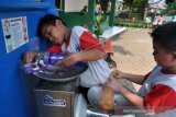 Pelajar SD mengisi botol minumnya di Kran Air Siap Minum, Taman Sempur, Kota Bogor, Jawa Barat, Senin (7/10/2019). Pemerintah Kota Bogor melalui Perusahaan Daerah Air Minum (PDAM) Tirta Pakuan Bogor menyediakan fasilitas Kran Air Siap Minum di ruang terbuka publik selain untuk mempermudah warga menikmati air minum juga untuk mengurangi penggunaan botol dan gelas plastik. ANTARA FOTO/Arif Firmansyah/ama.