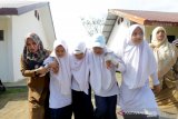 Pelajar bersama guru mengevakuasi korban bencana saat mengikuti simulasi evakuasi mandiri bencana gempa dan gelombang tsunami di SMPN 1 Baitussalam, Aceh Besar, Aceh, Selasa (8/10/2019). Simulasi evakuasi mandiri dikalangan pelajar yang digelar Badan Penanggulangan Bencana Aceh (BPBA) bertujuan membangun kesiapsiagaan bencana berbasis sekolah dan penguatan kapasitas manajemen sekolah dalam mengurangi korban akibat bencana alam. Antara Aceh/Irwansyah Putra.
