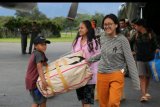 Sejumlah pengungsi mengangkat barang bawaannya ketika tiba dengan menumpang pesawat Hercules TNI AU di Bandar Udara Wamena, Papua, Rabu (9/10/2018). Sebanyak 87 orang pengungsi dari Jayapura yang didominasi warga asal Toraja tersebut kembali lagi ke Wamena. ANTARA FOTO/HO/Achmad Sugito/Humas Linjamsos/nym.