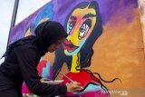 Seniman menyelesaikan karya seni graffiti dalam acara Ladies on Wall 2019 di Karawang, Jawa Barat, Minggu (13/10/2019). Acara tersebut diselenggarakan oleh Kementerian Pendidikan dan Kebudayaan bekerjasama dengan Ledies on Wall untuk mengapresiasi seniman graffiti perempuan di Indonesia. ANTARA FOTO/M Ibnu Chazar/agr