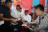 Bupati Banyuwangi Abdullah Azwar Anas (tengah) menandatangani buku 