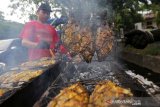 Pedagang membakar ikan untuk dijajakan di pasar takjil Ramadan, Lampineung, Banda Aceh, Aceh, Rabu (8/5/2019).


POTRET PERIKANAN ACEH 

Provinsi Aceh yeng berada di ujung barat pulau sumatra yang dikelilingi 
samudera Indonesia di wilayah barat selatan Aceh dan selat malaka serta perairan Andaman di wilayah Utara-Timur Aceh dengan panjang garis pantai 2.666,27 Km. Sedangkan luas perairannya mencapai 295.370 Km persegi, yang terdiri dari perairan teritorial dan kepulauan 56.563 Km persegi, serta perairan zona ekonomi eksklusif (ZEE) 238.807 Km persegi. 

Sebagai warga Aceh tentu patut bersujud syukur atas limpahan rahmat terhadap potensi perikanan dan kelautan serta memiliki nelayan yang handal dalam mengekploitasi kekayaan alam tersebut.
 
Potensi  perikanan dan kelautan Aceh diperkirakan mencapai 272,7 ribu ton/tahun, jumlah kapal penangkap ikan diperkirakan lebih 16 ribu unit dan jumlah nelayan yang menggali sumber daya kelautan berkisar 64 ribu orang lebih.

Potensi sumber daya kelautan dan perikanan telah menjadi salah satu tulang punggung perekonomian masyarakat Aceh, bukan hanya di laut , didaratan pun telah tumbuh galangan-galangan kapal kayu untuk mendukung sektor perindustrian dan perdagangan perikanan. 

Pemerintah daerah melalui program Aceh “Meugoe dan Meulaot”  juga terus berupaya meningkatkan pembangunan sektor kelautan dan perikanan dengan mengarahkan pada perbaikan sarana prasarana atau fasilitas dan teknologi perikanan serta jaringan pemasarannya.

Sejak 2006 Pemerintah Aceh telah membangun pelabuhan perikanan Lampulo yang dipersiapkan menjadi pelabuhan utama bertaraf Internasional dengan daya tampung kurang lebih 200 kapal penangkap ikan berukuran di bawah 40 GT. Pelabuhan ini pada masa yang akan datang diharapkan menjadi pintu ekspor hasil laut Aceh. 

Untuk mewujudkan mimpi tersebut, tentu bukan hanya memiliki galangan kapal yang berkualitas dan sarana serta prasarana pelabuhan yang mumpuni namun sektor pengolahan hasil laut juga harus ditingkatkan agar lebih professional sehingga kualitas produk tetap terjaga.

Kini Aceh telah memiliki tempat pengolahan ikan basah yang professional bahkan hasil olahannya telah mampu menembus pasar intenasional diantaranya Jepang, Malaysia, Singapura, Taiwan, Thailand dan Hongkong.

Ditingkat lokalpun, produk perikanan telah diolah menjadi berbagai produk yang mampu meningkatkan perekonomian keluarga dan menampung tenaga kerja. Semoga perikanan Aceh terus berkembang dan maju dimasa kini dan yang akan datang.

Foto dan Teks : Irwansyah Putra