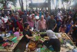 Pengunjung membeli makanan tradisional di Pasar Witwitan, Banyuwangi, Jawa Timur, Minggu (13/10/2019). Pasar tradisional yang hanya buka  dihari minggu tersebut, merupakan destinasi wisata kuliner khas Banyuwangi yang ramai dikunjungi wisatawan. Antara Jatim/Budi Candra Setya/zk.