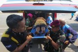 Petugas menggotong pengungsi dari Wamena yang sakit di Gapura Surya Nusantara, Pelabuhan Tanjung  Perak, Surabaya, Jawa Timur, Kamis (17/10/2019). Sekitar 519 pengungsi korban kerusuhan di Wamena, Kabupaten Jayawijaya, Provinsi Papua tiba di Surabaya dengan menumpang KM Dobonsolo. Antara Jatim/Didik Suhartono/ZK