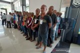 Sejumlah Pekerja Migran Indonesia (PMI) berbaris untuk menjalani pendataan saat tiba di Pos Lintas Batas Negara (PLBN) Entikong, Kabupaten Sanggau, Kalimantan Barat, Rabu (16/10/2019). KJRI Kuching Sarawak mengawal 53 PMI bermasalah yang dideportasi Malaysia melalui Depot Imigresen Bekenu Miri karena telah melanggar Undang-Undang Imigrasi setempat yaitu bekerja tanpa ijin. Sebelum dipulangkan ke Indonesia, mereka harus menjalani tahanan selama tiga bulan. ANTARA FOTO/Agus Alfian/jhw