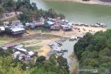 Kondisi Waduk Riam Kanan yang volume airnya menyusut di Desa Tiwingan Lama, Kabupaten Banjar, Kalimantan Selatan, Jumat (18/10/2019). Akibat musim kemarau, waduk seluas 8.000 hektare dan menjadi bahan baku utama untuk Pembangkit Listrik Tenaga Air (PLTA) Ir. Pangeran Mochamad Noor tersebut mengalami penyusutan volume air dengan penurunan permukaan air waduk mendekati ambang batas sehingga membuat kinerja turbin PLTA terganggu. Foto Antaranews Kalsel/Bayu Pratama S.