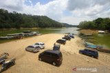 Kondisi Waduk Riam Kanan yang volume airnya menyusut di Desa Tiwingan Lama, Kabupaten Banjar, Kalimantan Selatan, Jumat (18/10/2019). Akibat musim kemarau, waduk seluas 8.000 hektare dan menjadi bahan baku utama untuk Pembangkit Listrik Tenaga Air (PLTA) Ir. Pangeran Mochamad Noor tersebut mengalami penyusutan volume air dengan penurunan permukaan air waduk mendekati ambang batas sehingga membuat kinerja turbin PLTA terganggu. Foto Antaranews Kalsel/Bayu Pratama S.