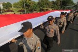 Polisi membawa Bendera Merah Putih saat Parade Merah Putih Indonesia Damai di Surabaya, Jawa Timur, Sabtu (19/10/2019). Kegiatan dengan kirab Bendera Merah Putih sepanjang 210 meter dan doa bersama itu digelar untuk menjaga dan merawat kebhinekaan yang ada di Indonesia. Antara Jatim/Didik Suhartono/ZK