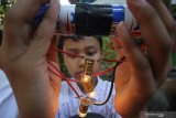 Murid kelas 6 SD Sekolah Alam Insan Mulia (SAIM) Fahri Danis Mirza Priyoyuono menunjukkan rangkaian lampu paralel menggunakan daya dari baterai saat pameran sains di Surabaya, Jawa Timur, Sabtu (19/10/2019). Pameran sains tersebut merupakan praktik secara langsung yang bertujuan untuk menumbuhkan minat belajar para murid dalam bidang ilmu pengetahuan alam. Antara Jatim/Moch Asim/zk.